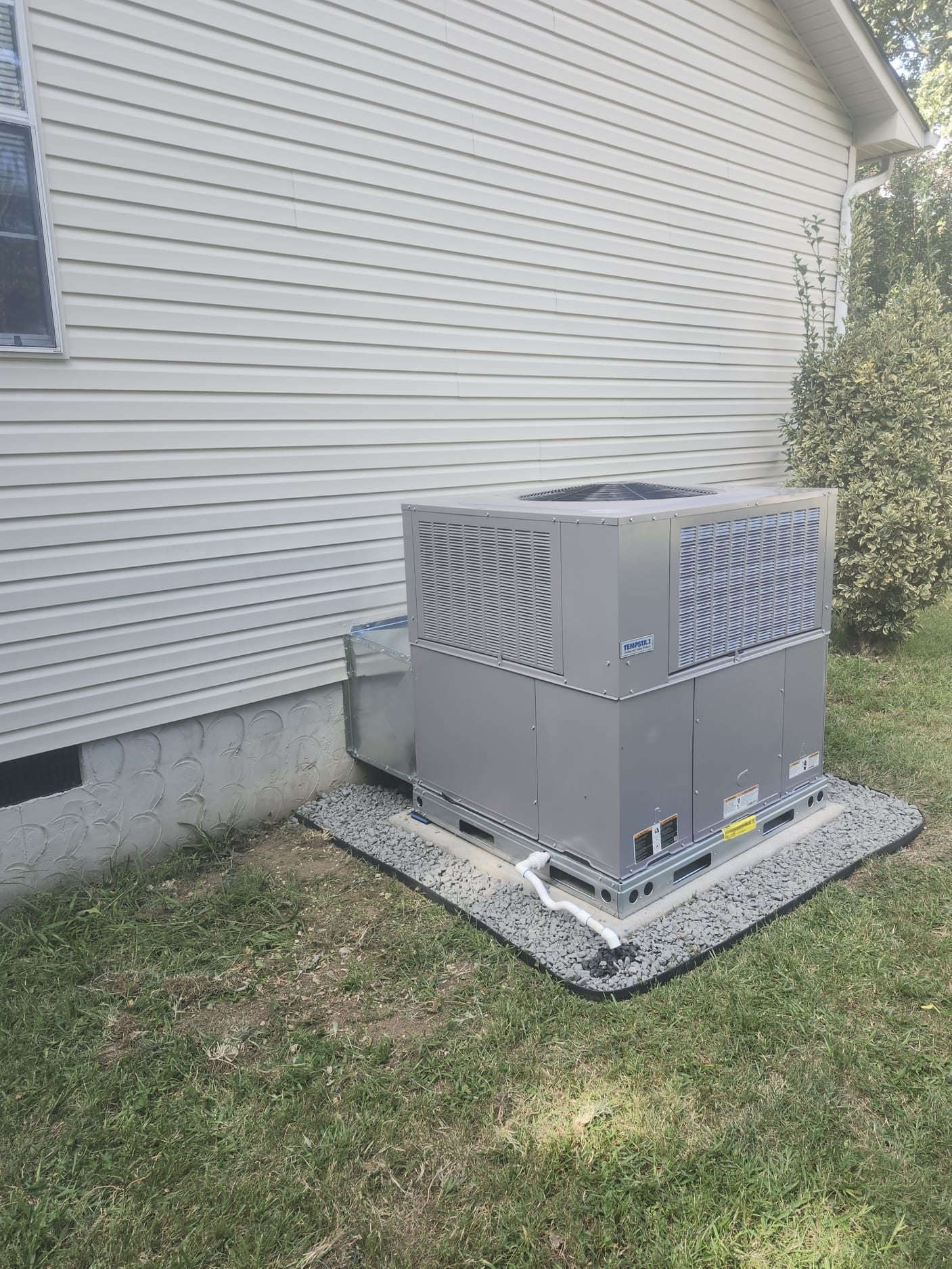 A clean and recent packaged HVAC installation with a good service setup
