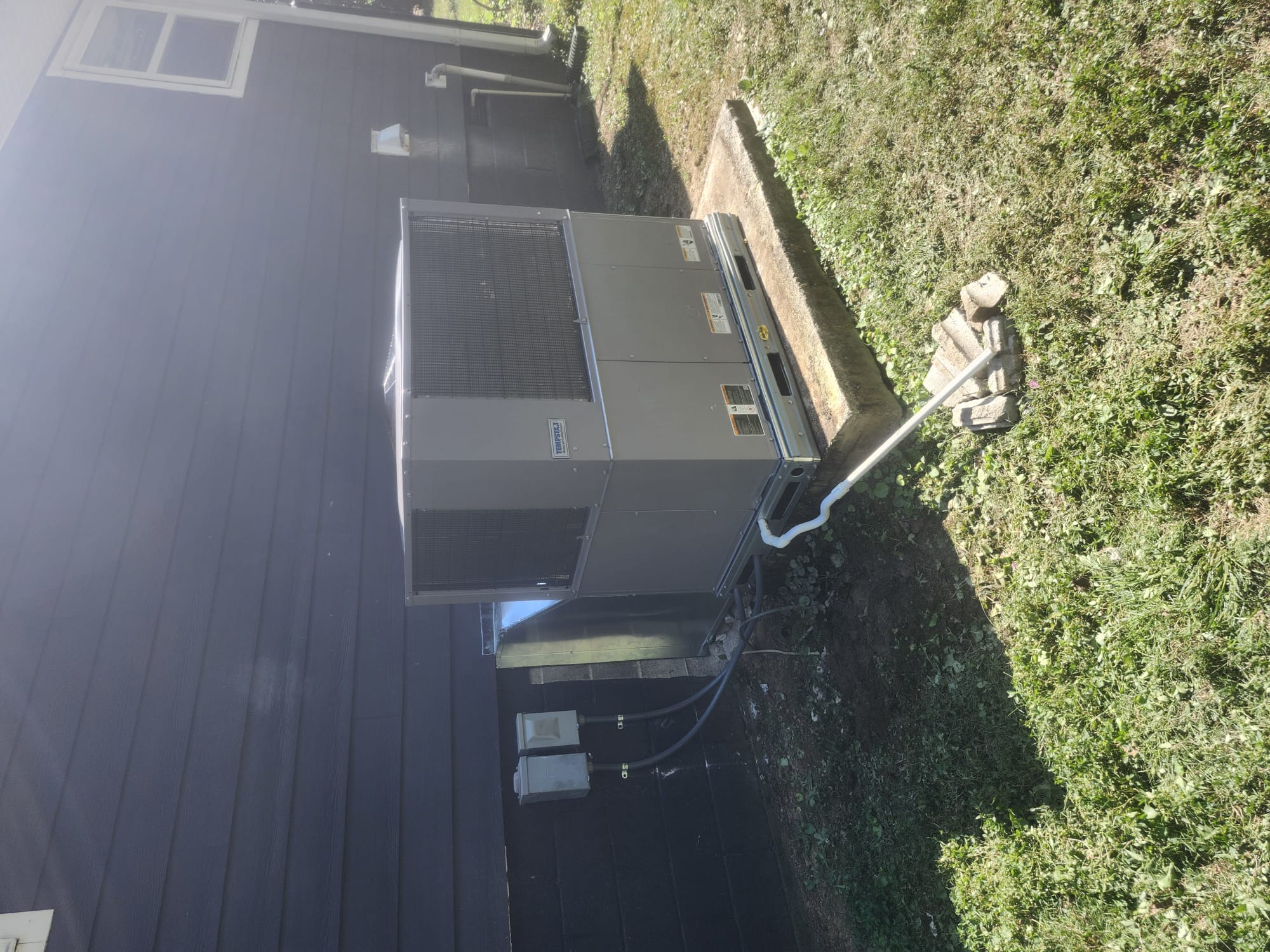 Completed HVAC package unit installation with condensate drain