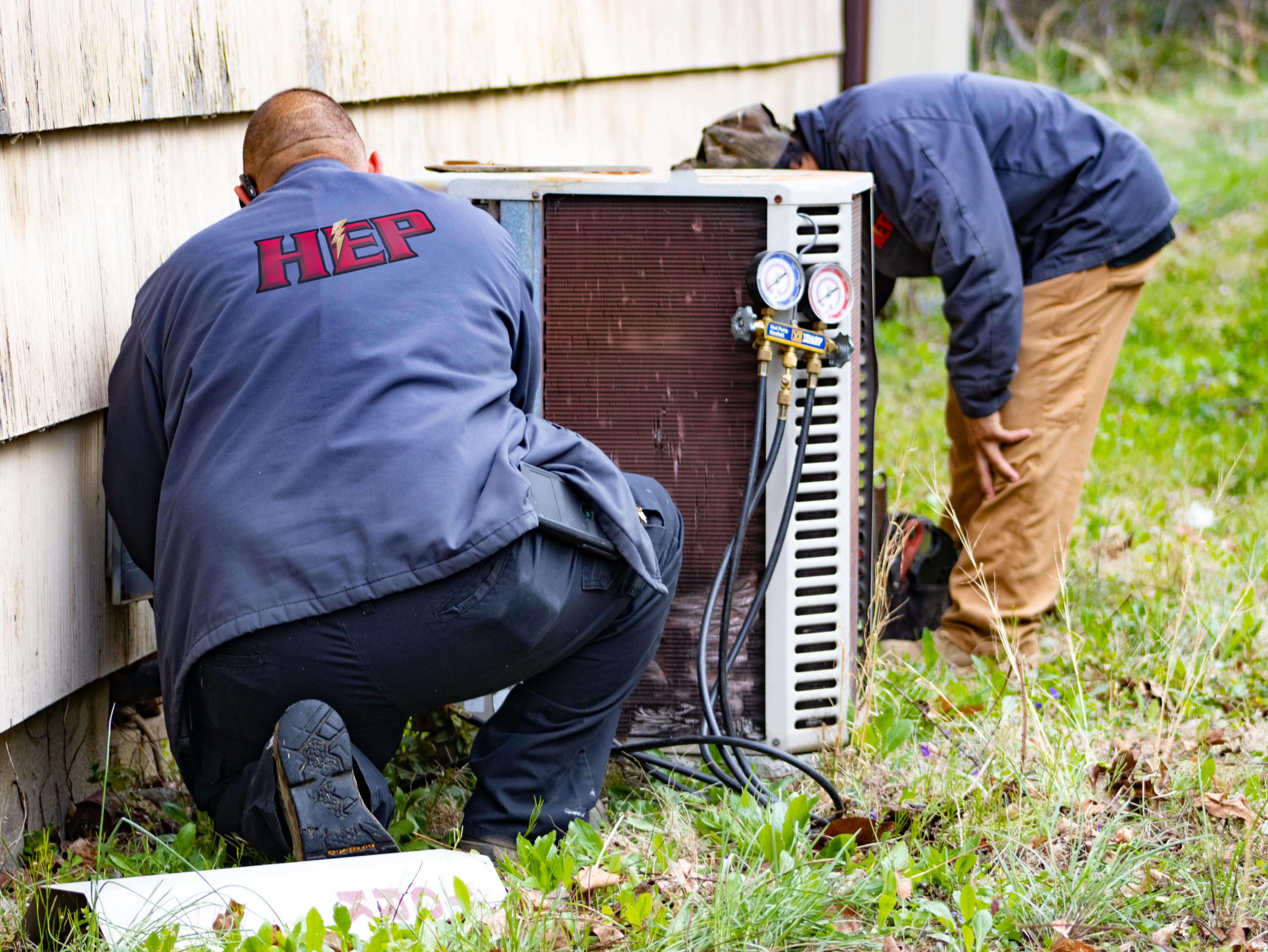 workers replacing central air conditioning system