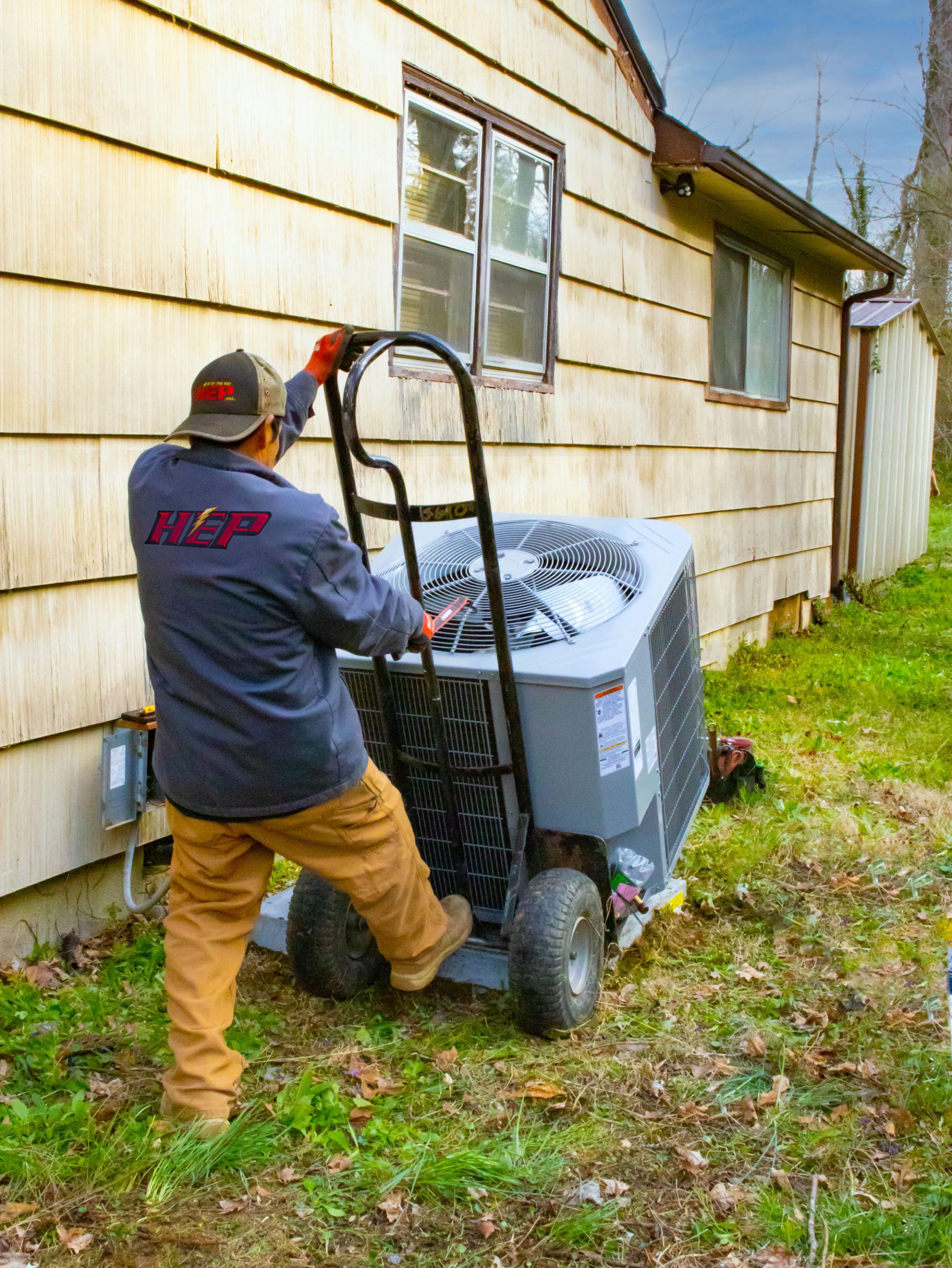 Technician hauling a new HVAC unit in Knoxville, Tennessee